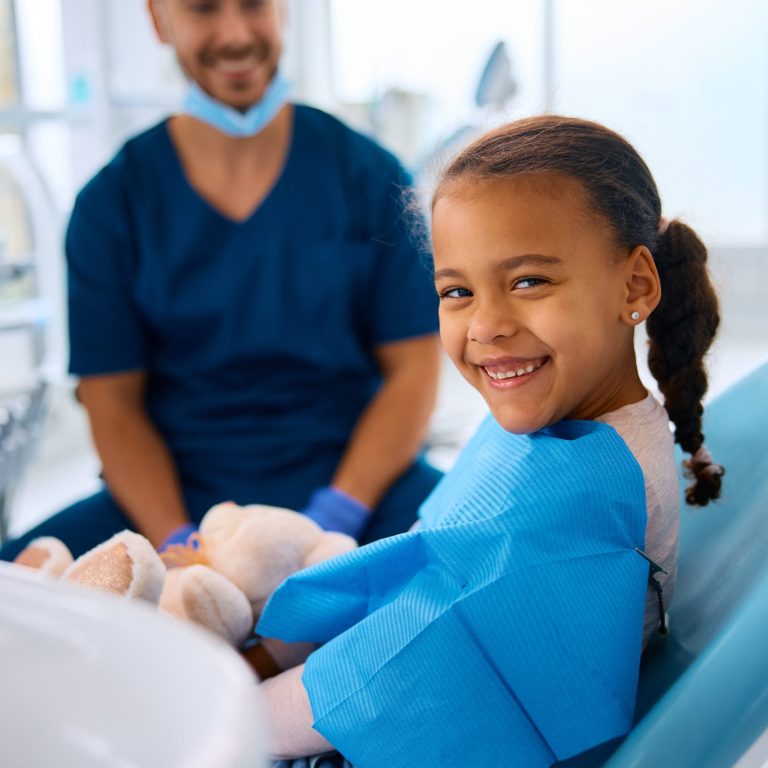 Happy African American girl having appointment at dentist's office.